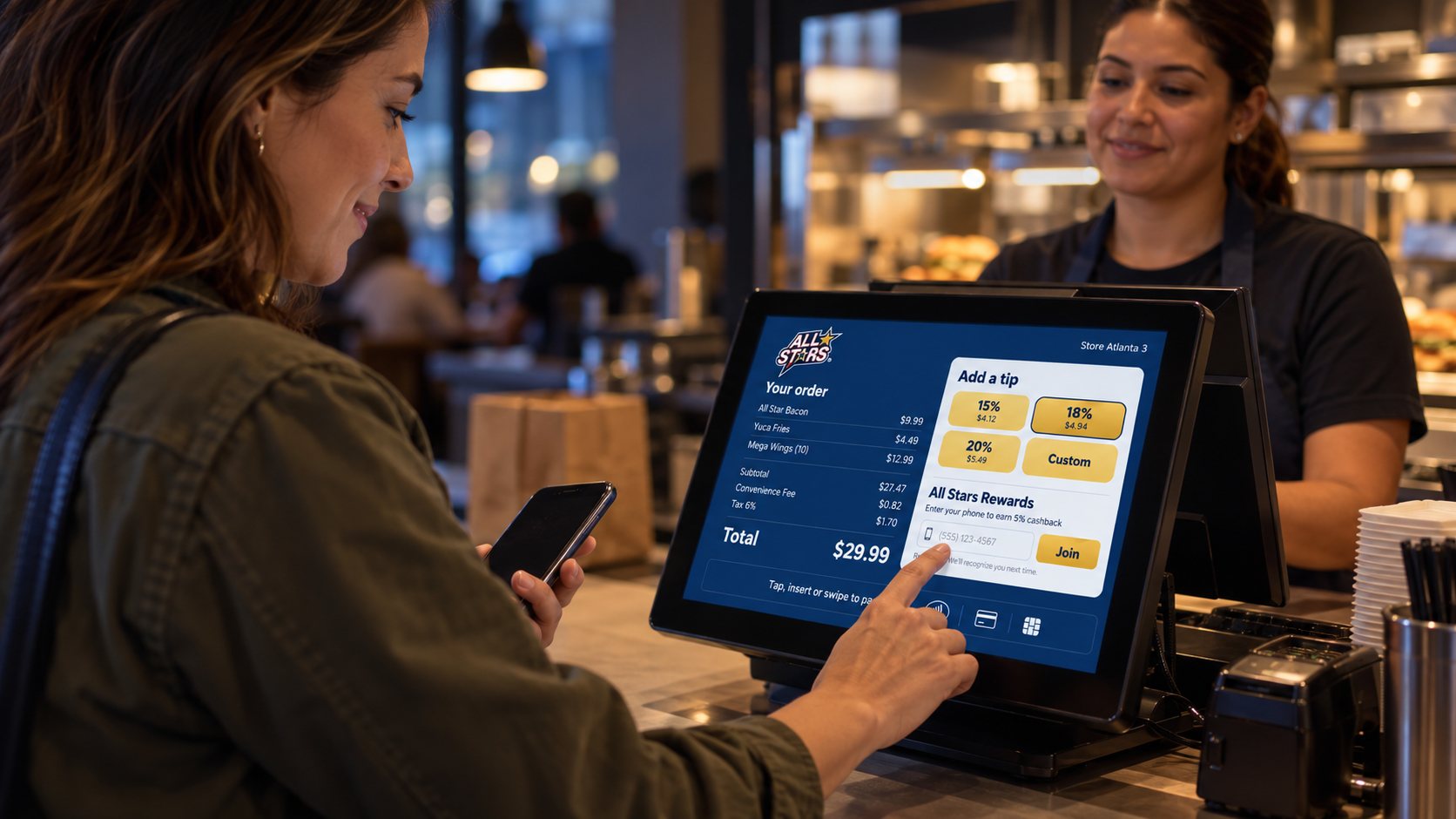 Customer paying with a phone on the Chipple customer screen while the cashier smiles.